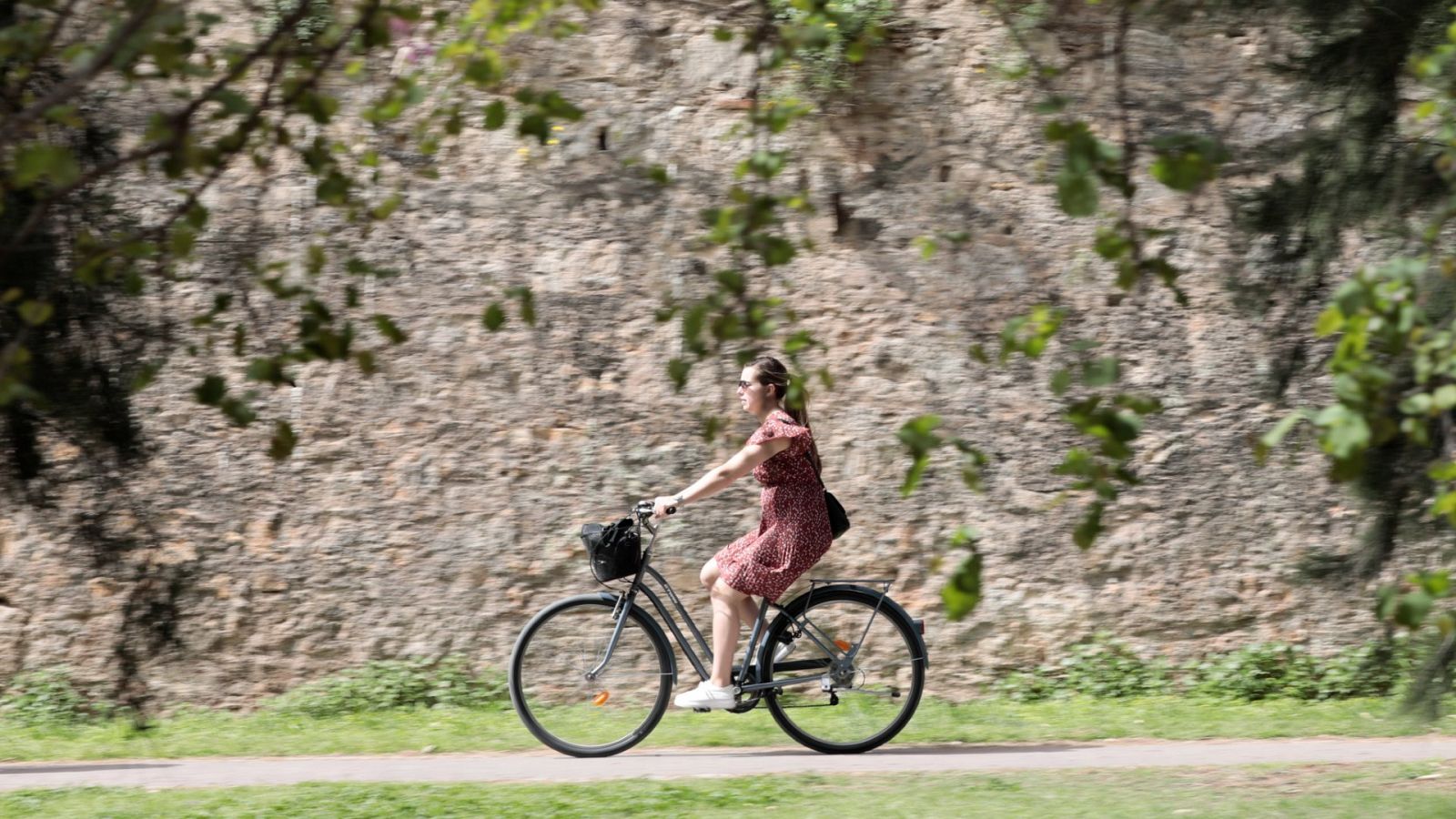 Una joven pasea en bici por el parque del antiguo cauce del Turia, en Valencia