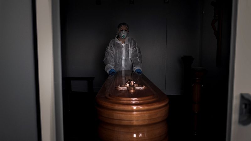 Una operaria transporta un ataúd con un fallecido por coronavirus en Ourense, en abril de 2020