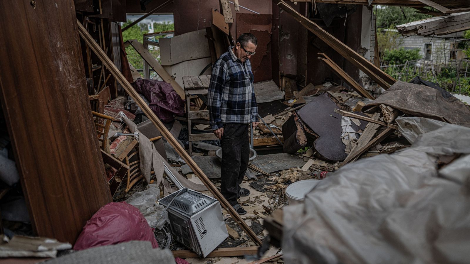 Mikeal entre las ruinas de su casa destruida por el impacto de la artillería rusa