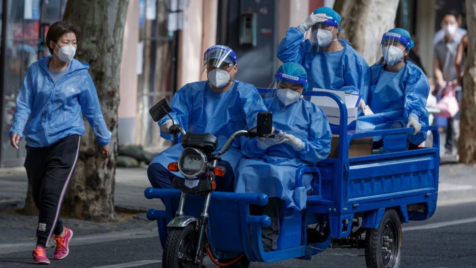 Los trabajadores de la salud viajan en una motocicleta de carga antes de que se levante el confinamiento en Shanghái, China.