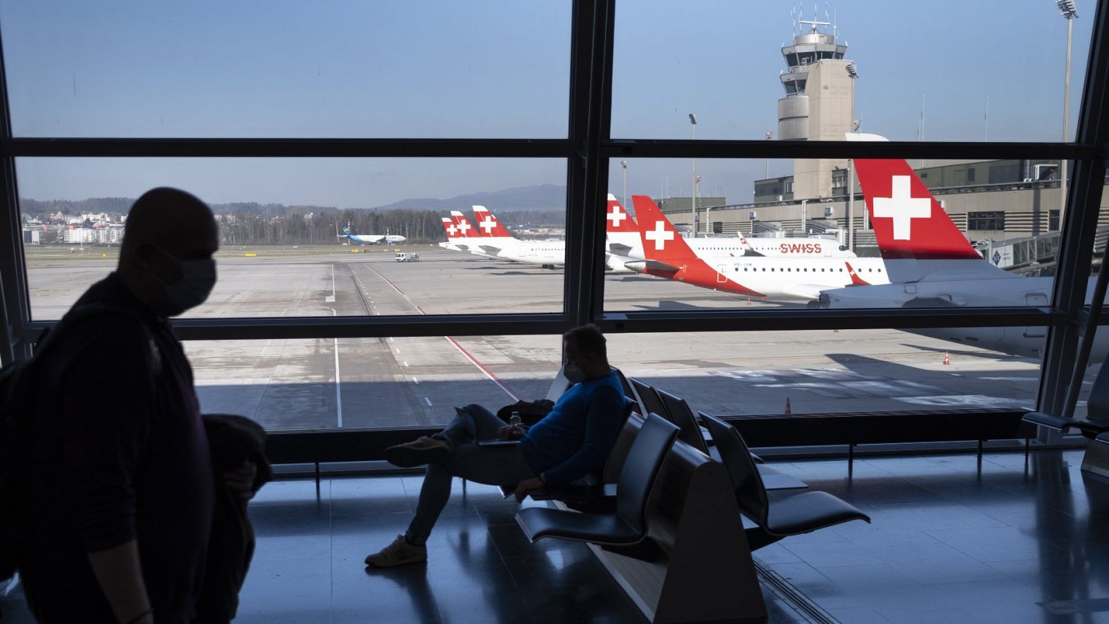 Pasajeros esperan subir a un avión en el aeropuerto de Zúrich