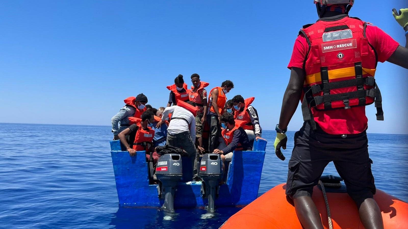 Integrantes de la ONG española Salvamento Marítimo ponen a salvo a varias personas en aguas del Mediterráneo.