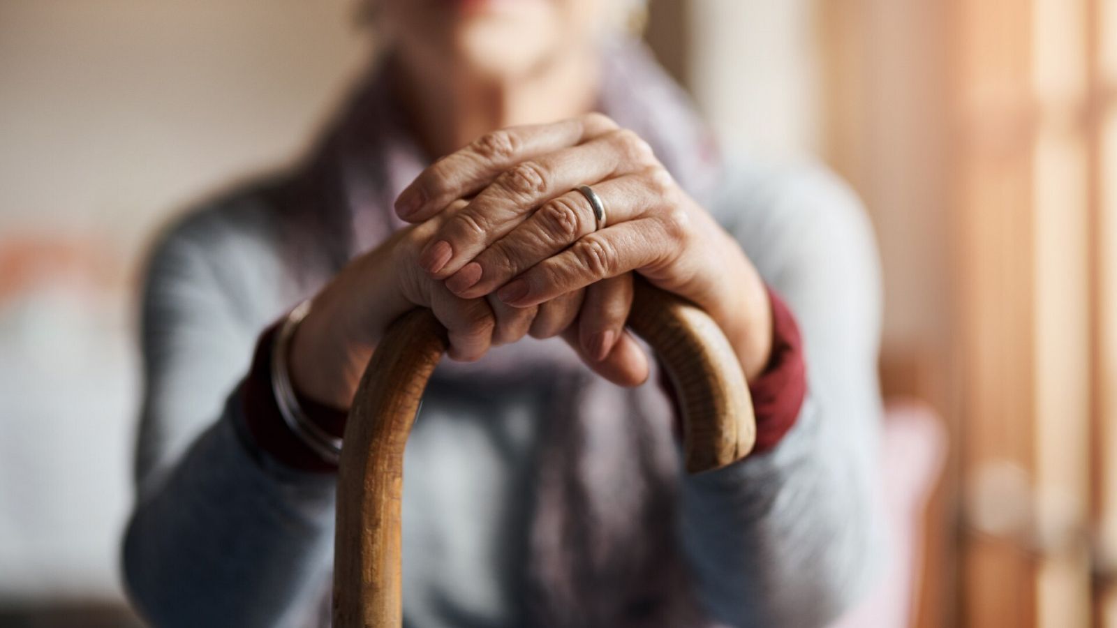 Una mujer apoyada en un bastón