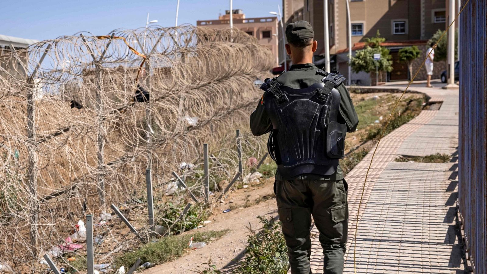 Un miembro de las fuerzas de seguridad fronterizas de Marruecos de espaldas junto a la valla