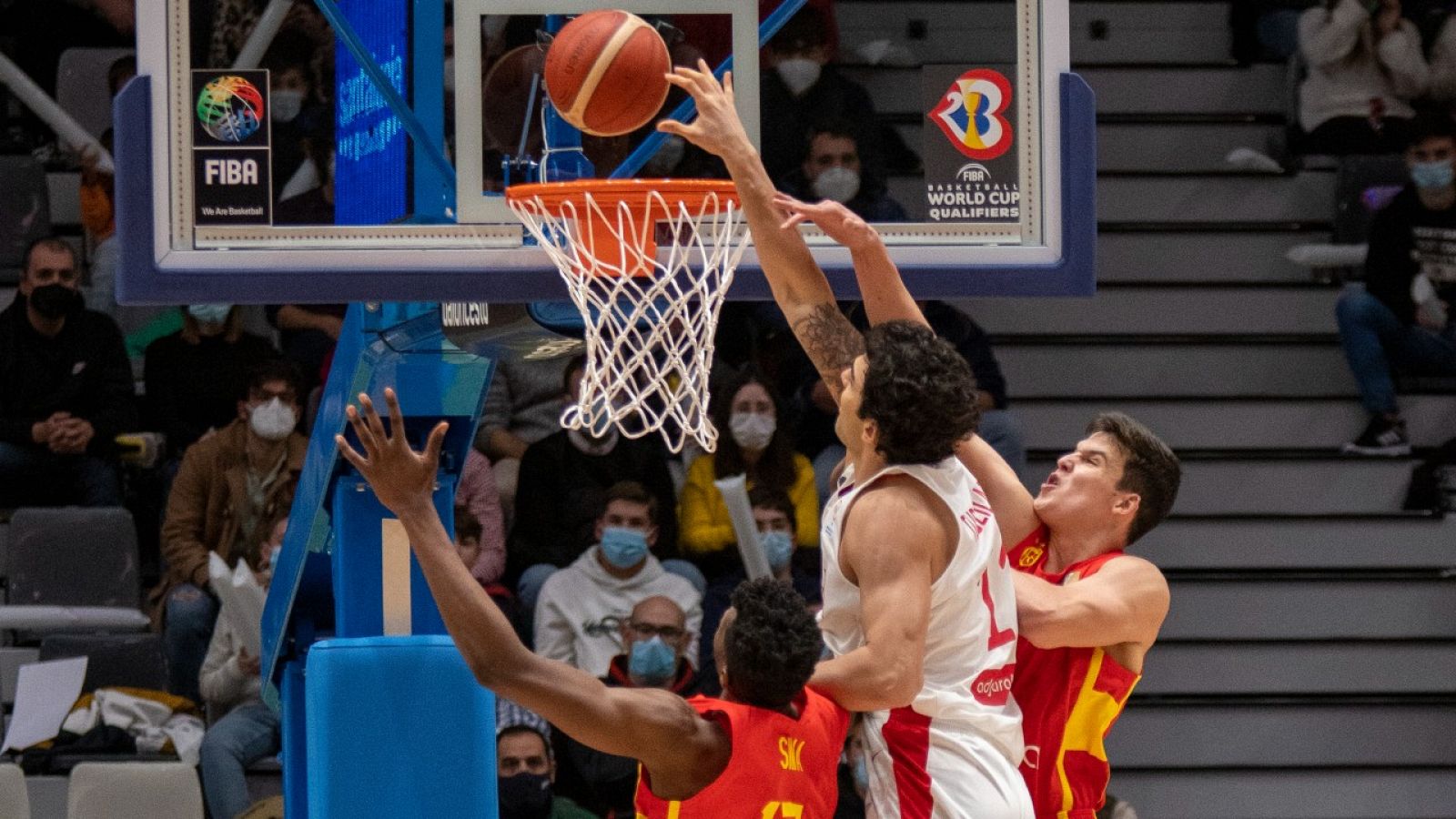 Jaime Pradilla (d) y Yankuba Sima (i), saltan por el balón con el pívot de Georgia, Giorgi Turdziladze.