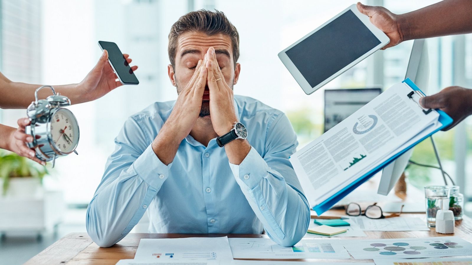 Un empleado abrumado por el trabajo en la oficina