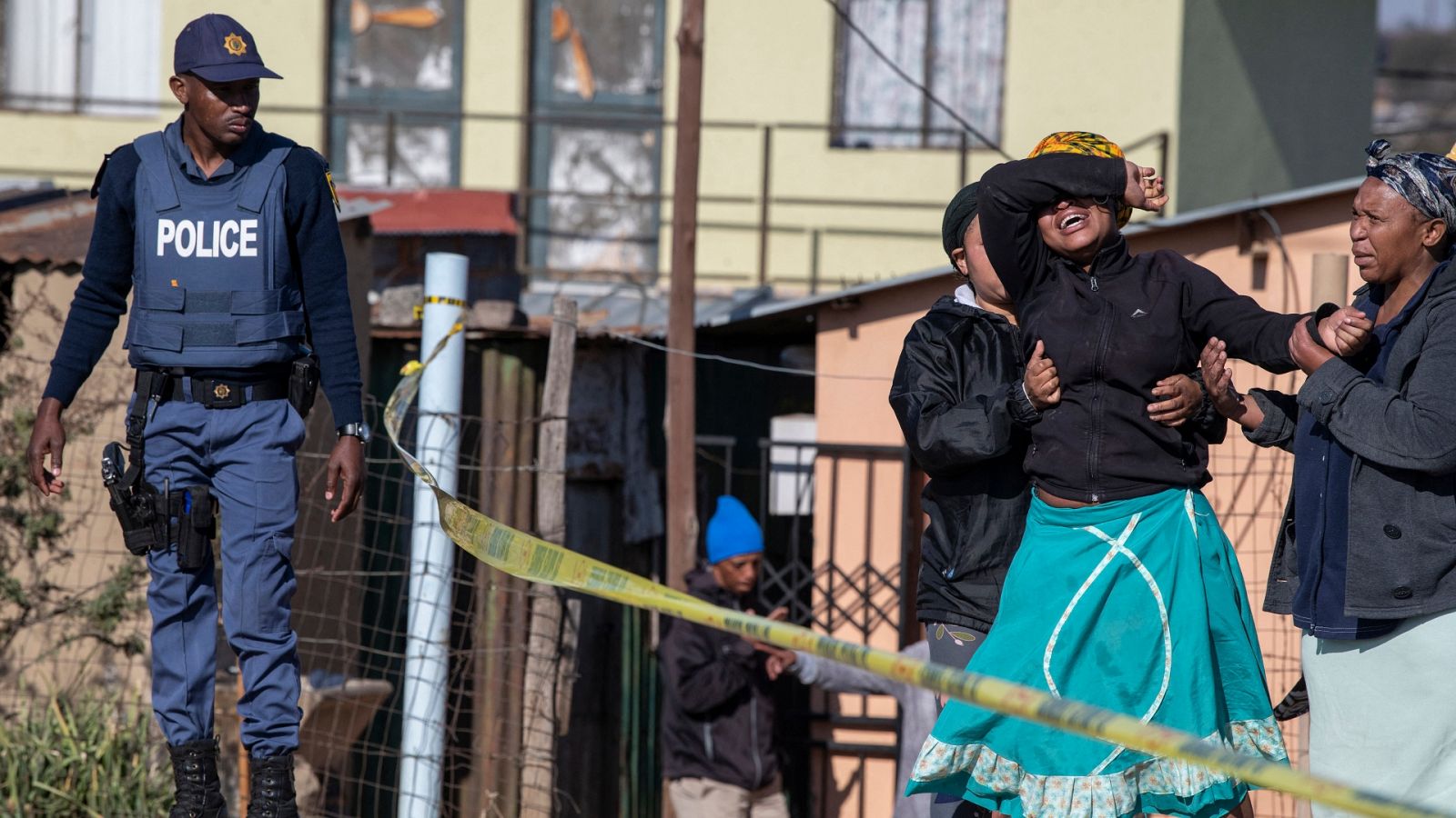 Una familiar de una de las víctimas llora cerca de la escena del crimen en Soweto, Sudáfrica.