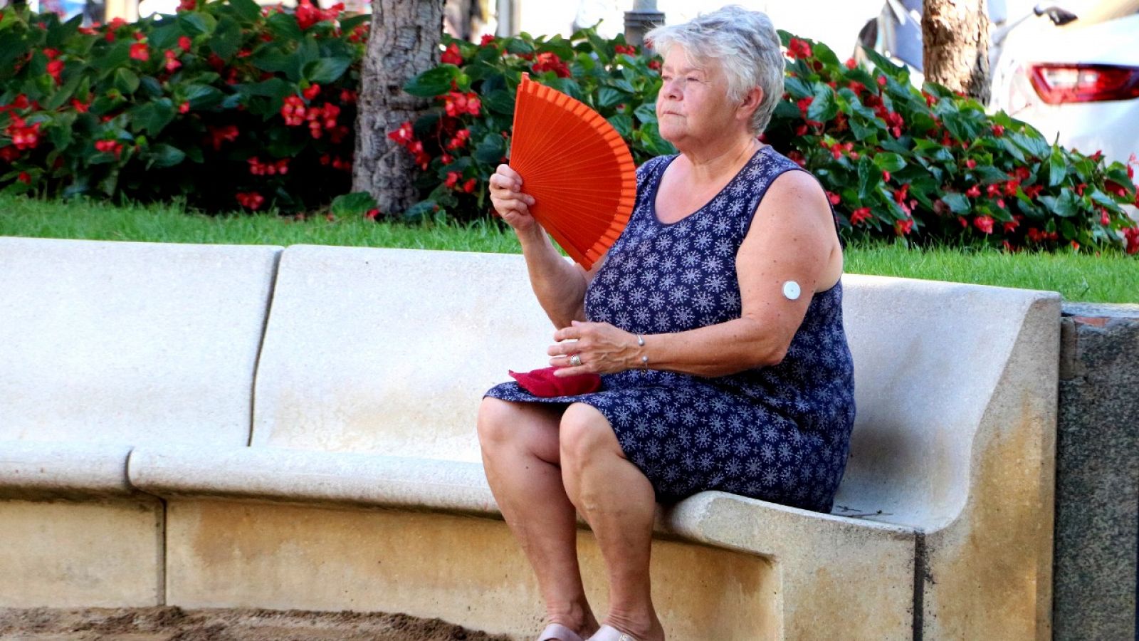 Una dona fent-se vent amb un ventall en una plaça pública de Figueres (Arxiu)