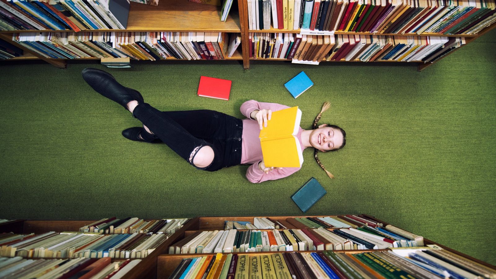 Una joven lee en el suelo de una librería