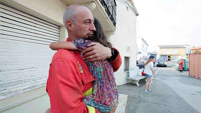 Un vecino sostiene una niña en brazos en Morasverdes (Salamanca)