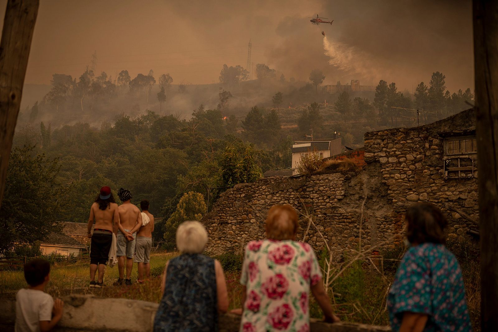 Varios vecinos abandonan las inmediaciones del incendio forestal registrado en Riodolas, en Carballeda de Valdeorras (Ourense)