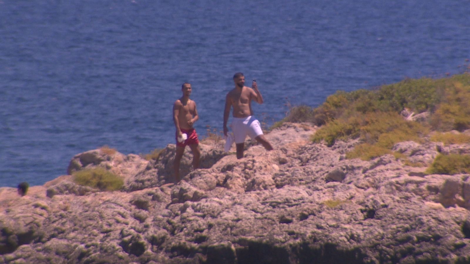 Dos banyistes sobre un illot a Calvià.