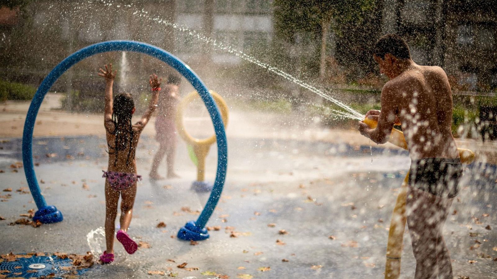 Niños juegan en la fuente de un parque en plena ola de calor