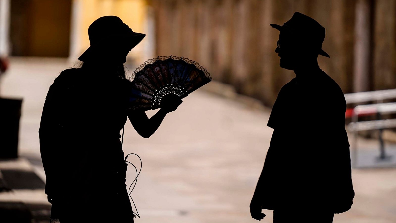 Una pareja de turistas espera a la sombra dentro del Patio de Los Naranjos en Córdoba