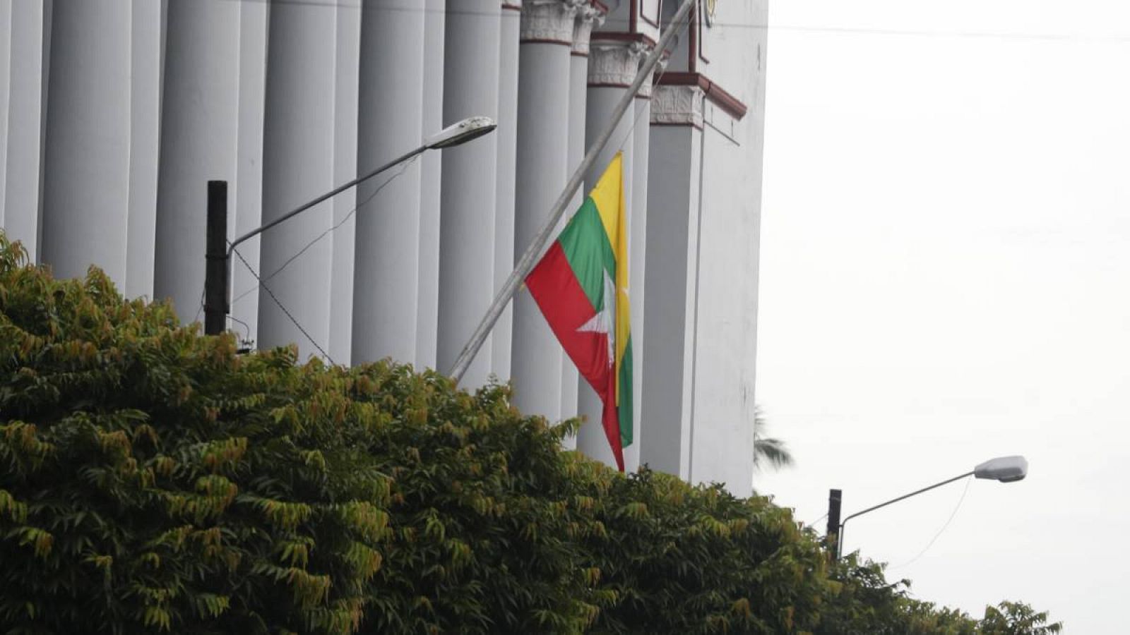 Una bandera de Myanmar ondea a media asta en el edificio de la autoridad portuaria de Myanmar en Yangon, Myanmar.
