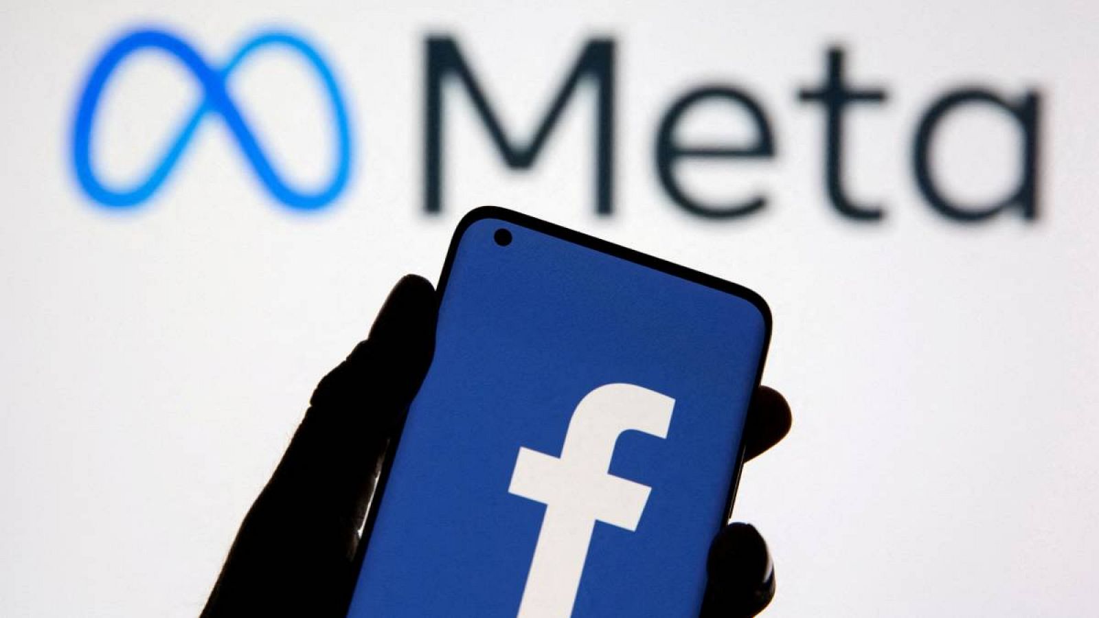 Un teléfono inteligente con el logotipo de Facebook frente al logotipo de cambio de marca de Facebook, Meta