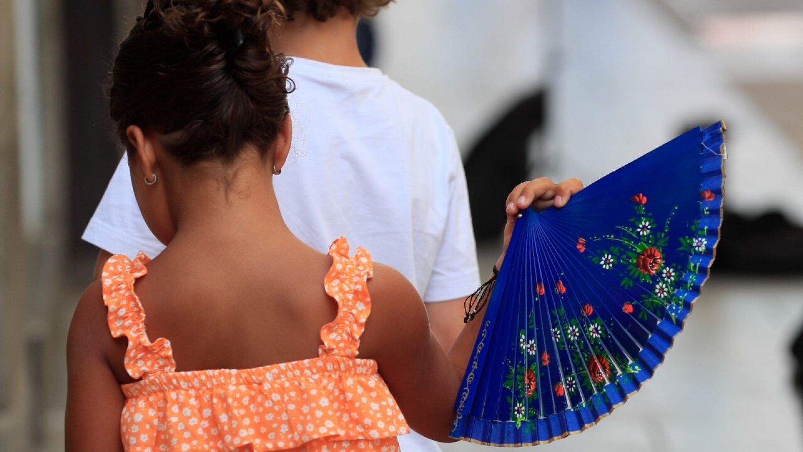 Una niña mitiga el calor con un abanico en el centro de Madrid.