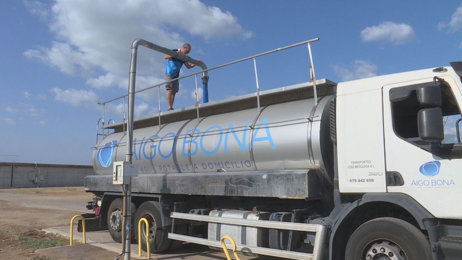 Un treballador d'Aigo Bona carregant un dels camions amb aigua dessalada