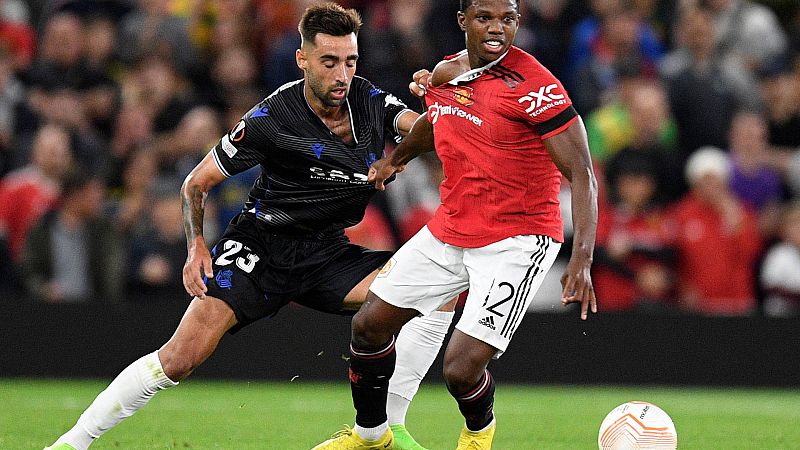 Brais Méndez (i) y Tyrell Malacia se agarran en un lance del Manchester United - Real Sociedad