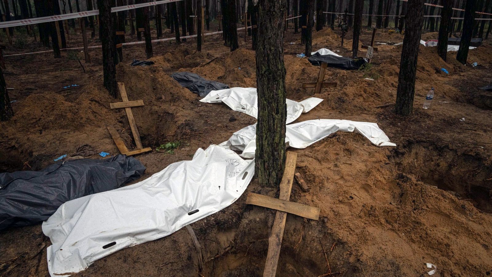 Exhumación de cadáveres en una fosa en Izium, ciudad recientemente reconquistada por las tropas ucranianas. Foto: AP Photo/Evgeniy Maloletka