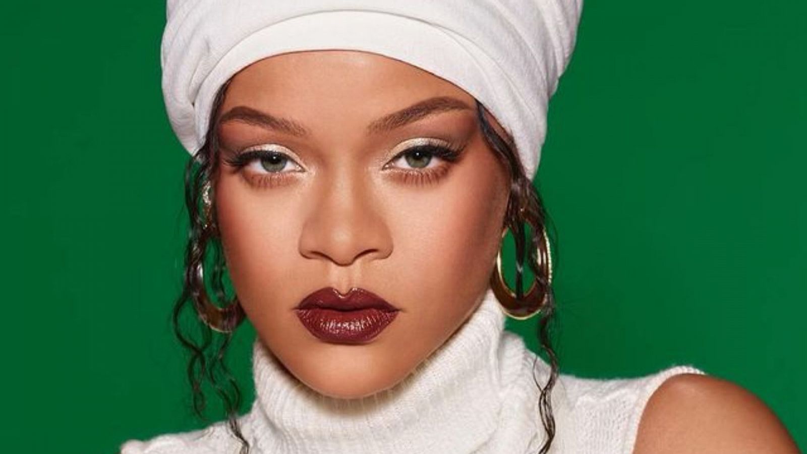 Rihanna con un recogido de un pañuelo blanco sobre un fondo verde