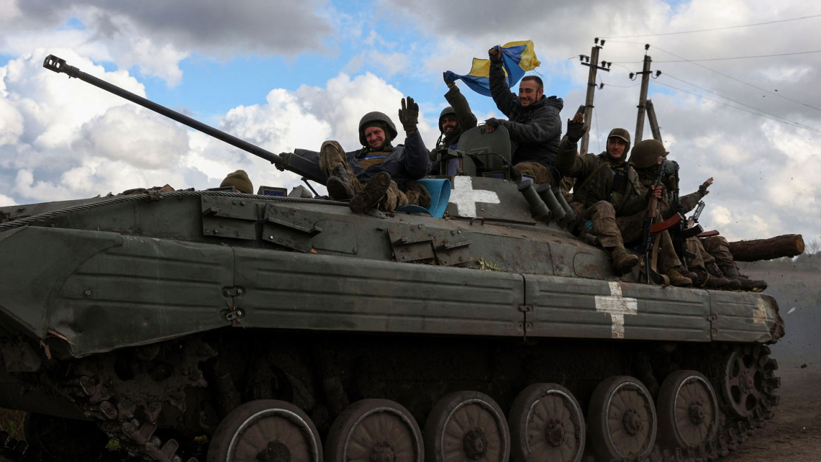 Soldados ucranianos ondean una bandera de su país en una carretera cerca de Limán, en la región de Donetsk