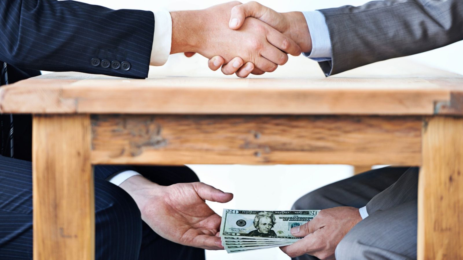 Cierre de un acuerdo empresarial con dinero bajo mano