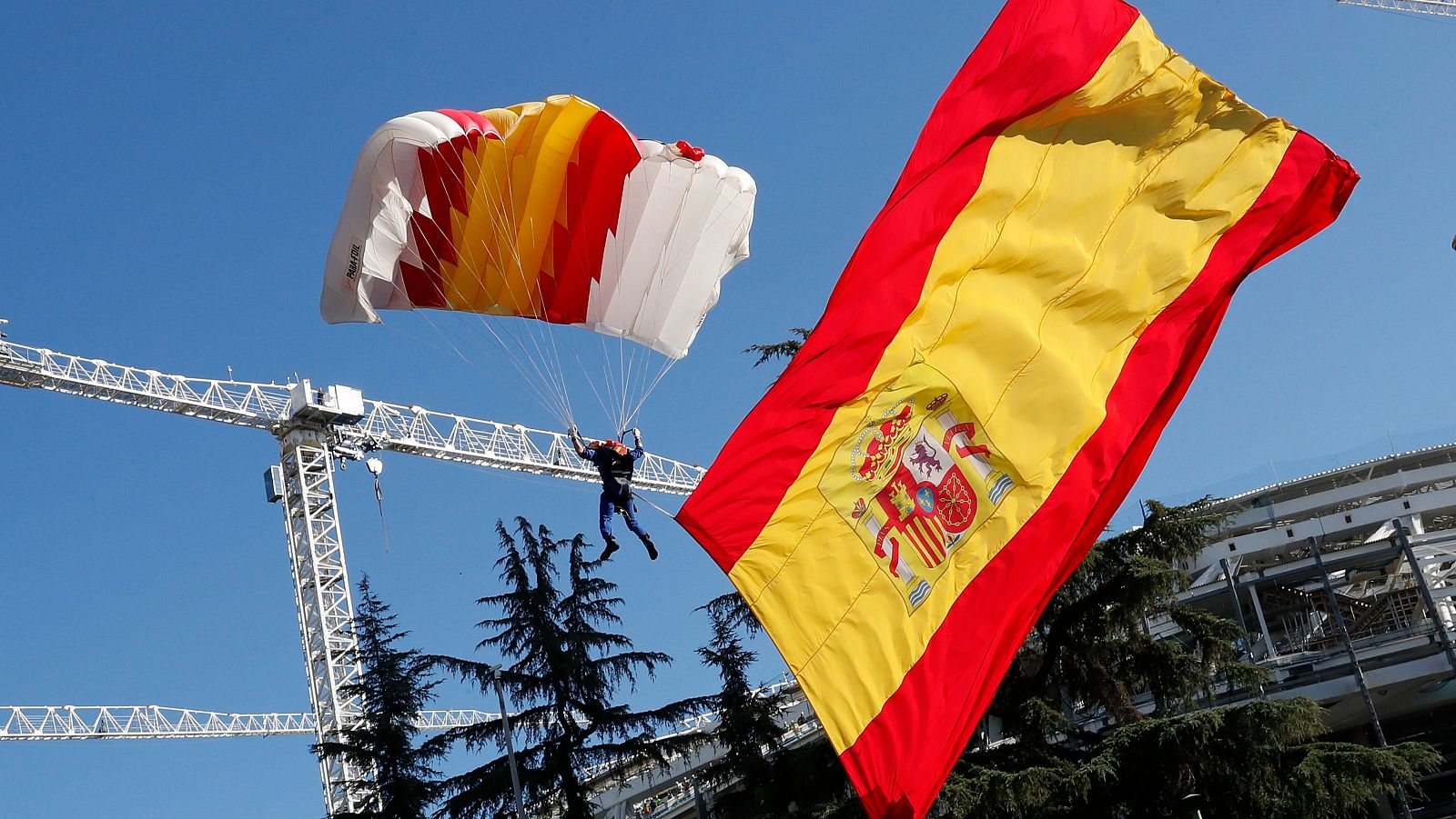 El soldado Óscar García García realiza un salto con la bandera de España desplegada.