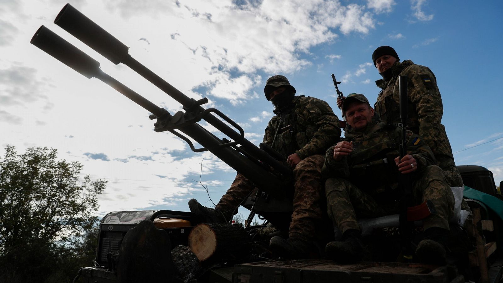 Tres soldados ucranianos encima de un tanque de combate