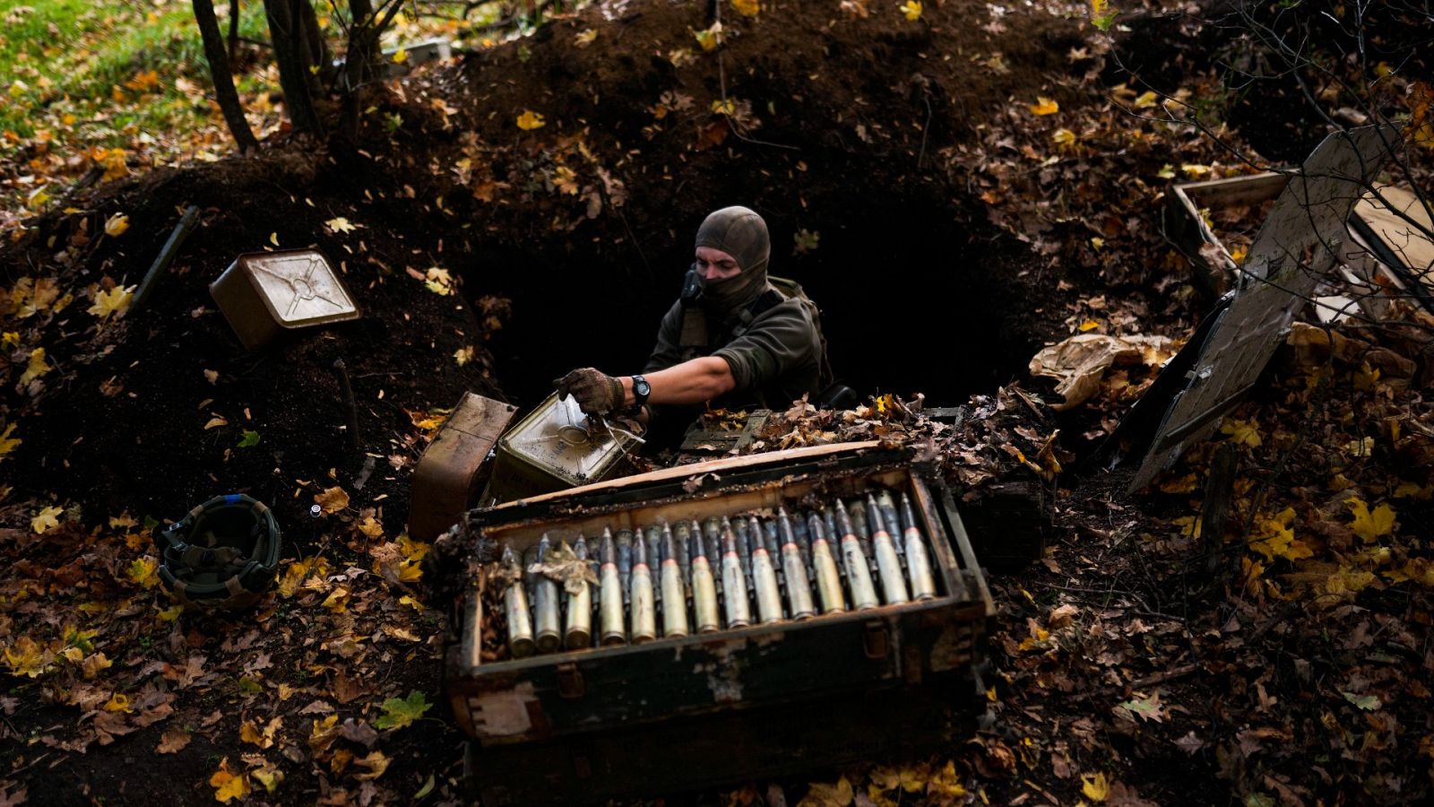 Un soldado ucraniano recoge munición dejada por las tropas rusas en su huida de territorio ocupado