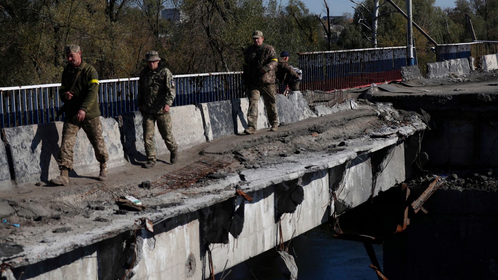 Soldados ucranianos cruzan un puente dañado en la ciudad de Kupiansk, al este de Járkov