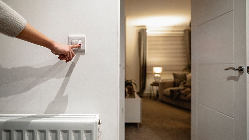 Una mujer apaga la luz en el salón de su casa