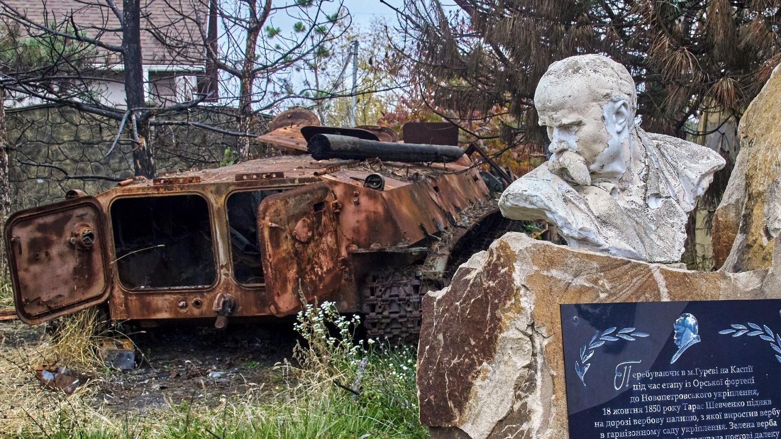 Monumento al poesta ucraniano Taras Shevchenko junto a un vehículo blindado destruido en la localidad de Cherkaski Tyshky, en Járkov