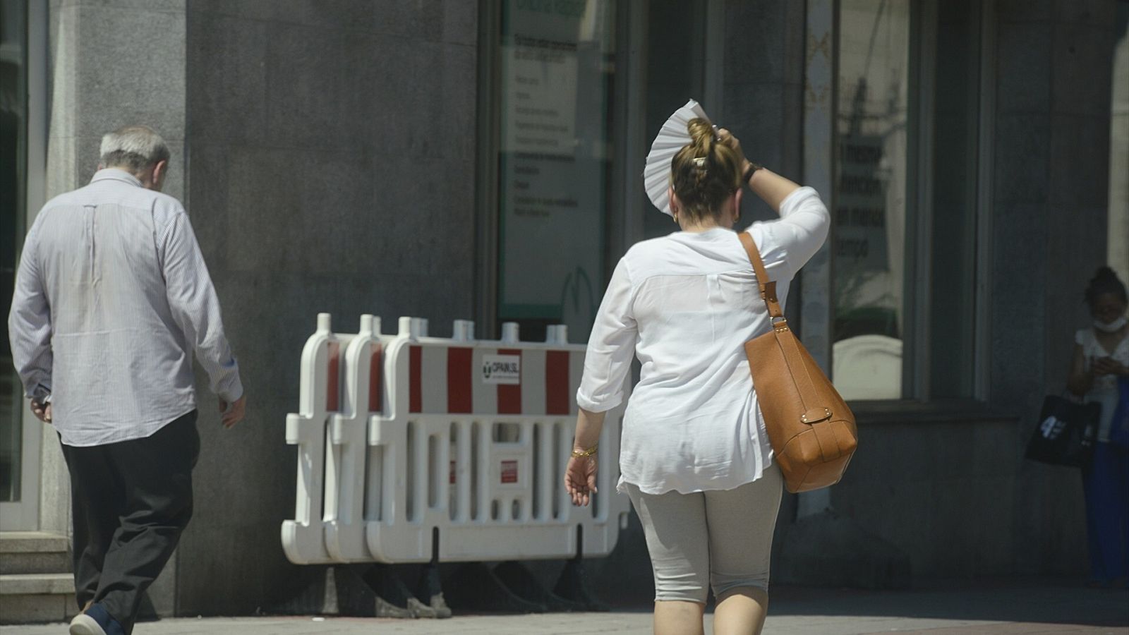 Dos personas caminan por una v&iacute;a en plena ola de calor