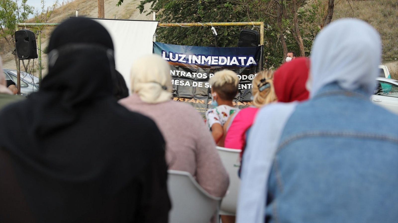 Varias personas participan en una concentración con motivo del aniversario del corte de electricidad en la Cañada Real