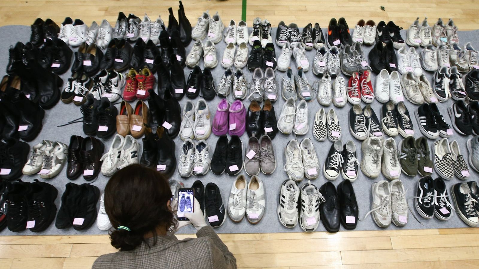 Una policía comprueba los zapatos de las víctimas de la estampida que se produjo durante la celebración de Halloween, en Seúl
