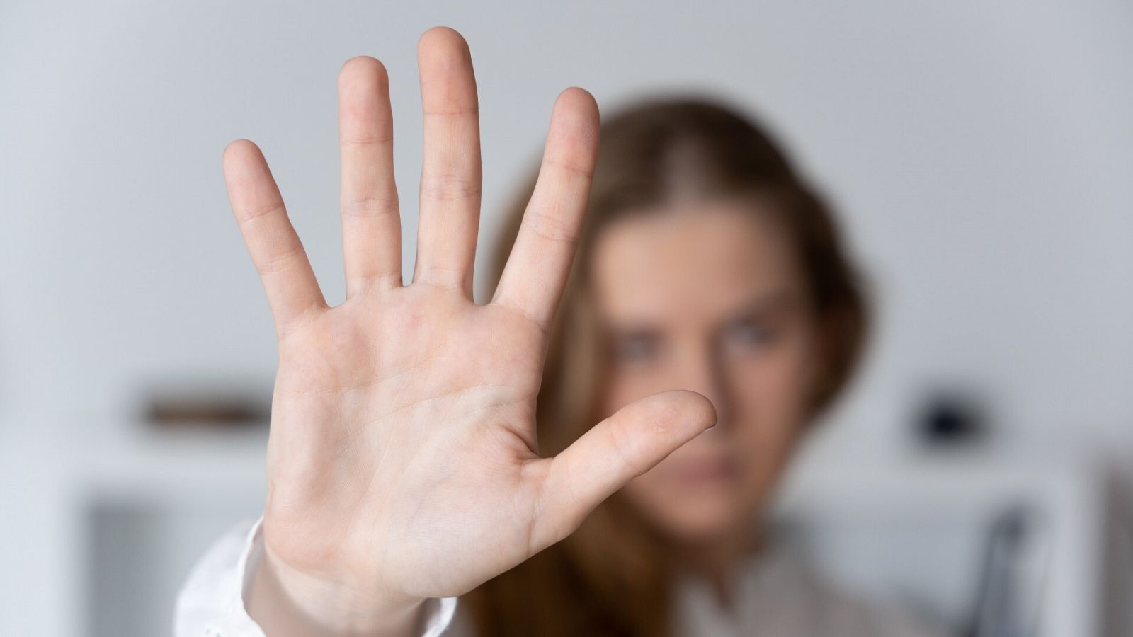 Una mujer enseña la palma de la mano en señal contra la violencia machista