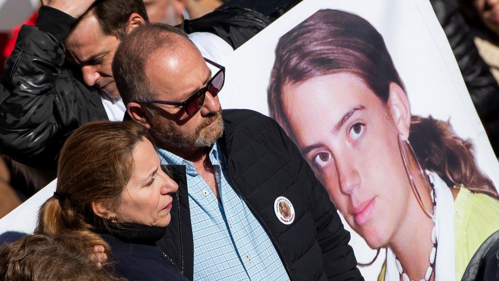 Los padres de Marta del Castillo se abrazan durante una manifestación. Junto a ellos hay una pancarta con la foto de su hija.