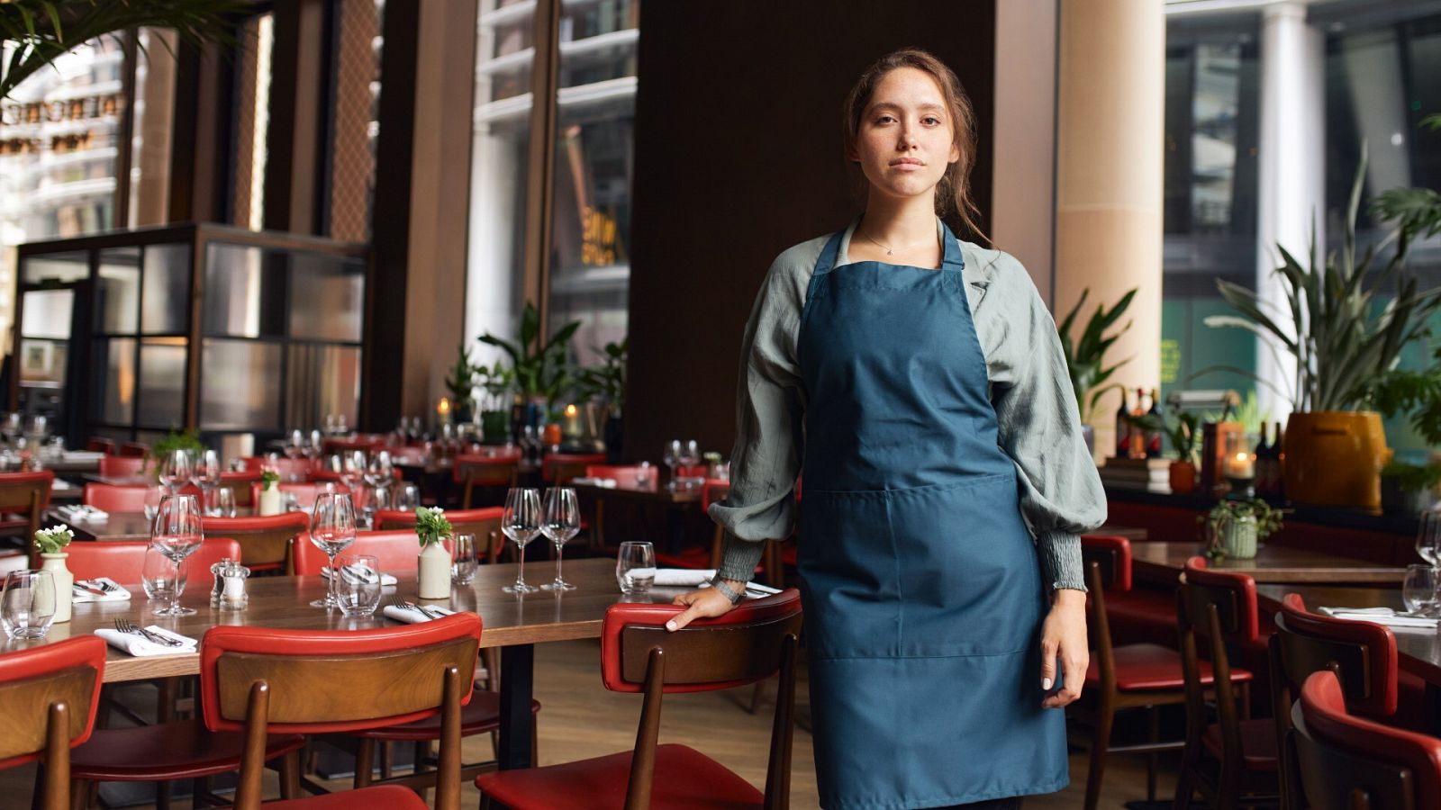 Una camarera en un restaurante mirando hacia la cámara