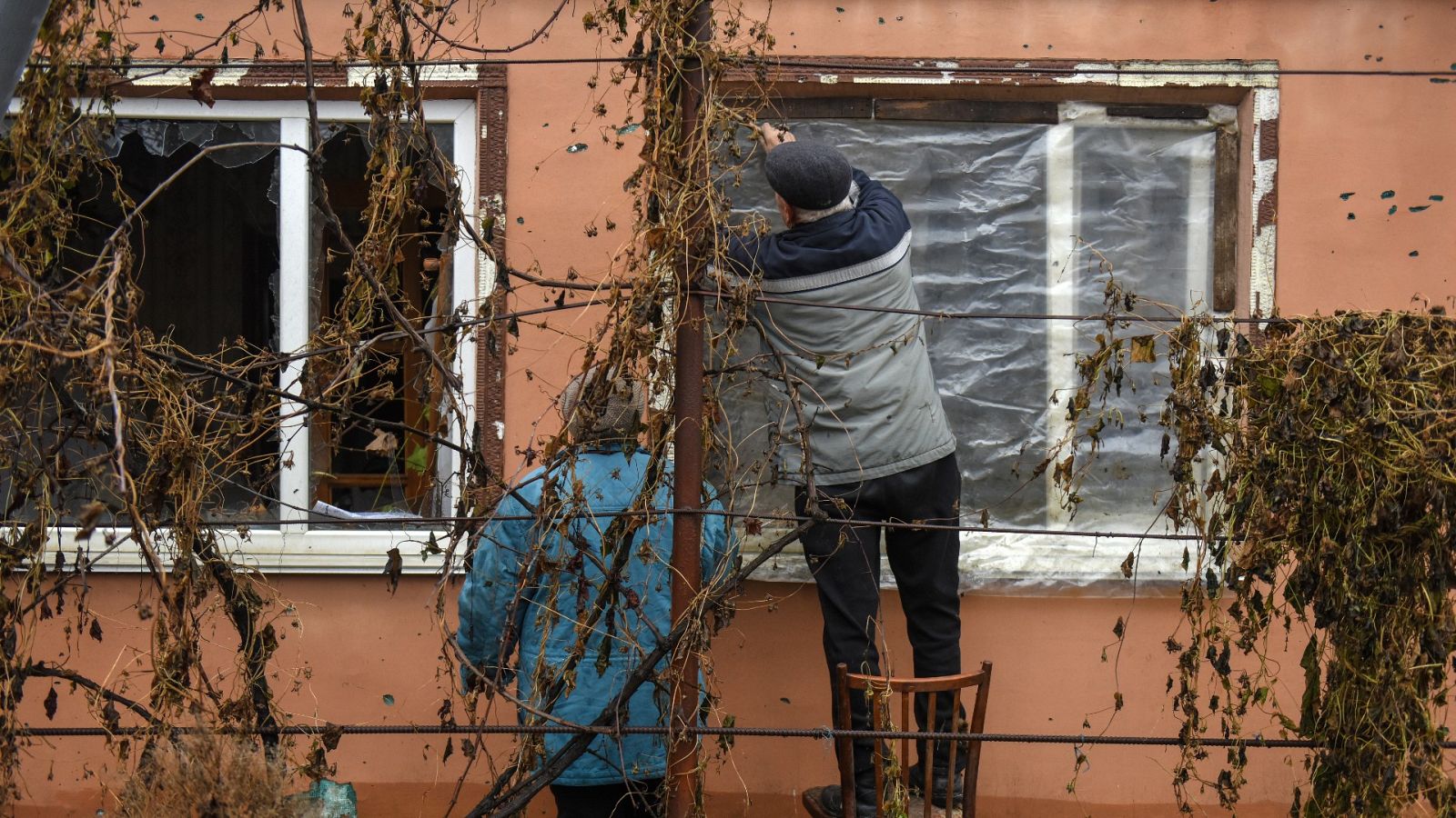 Svitlana y Leonid reparan una ventana de su vivienda en la localidad de Posad-Pokrovske, en la región de Jersón