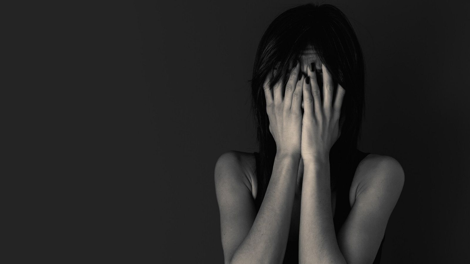 Una mujer se tapa el rostro con las manos