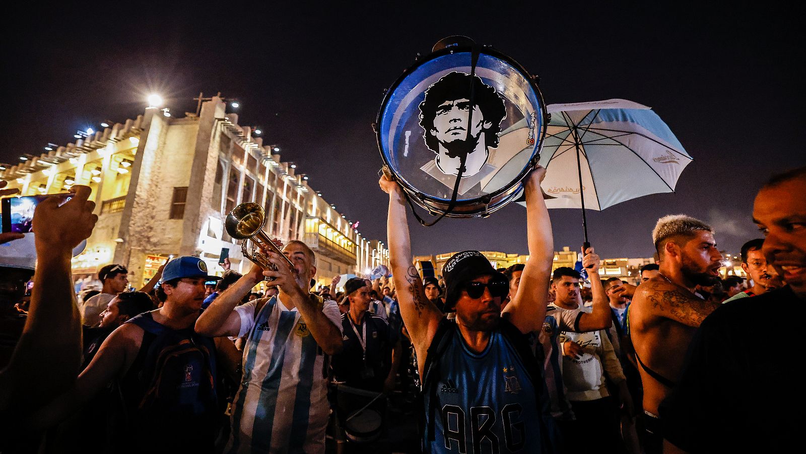 Cientos de aficionados argentinos realizan un banderazo de apoyo a la selección albiceleste en el barrio de Souq Waqif, en Doha.