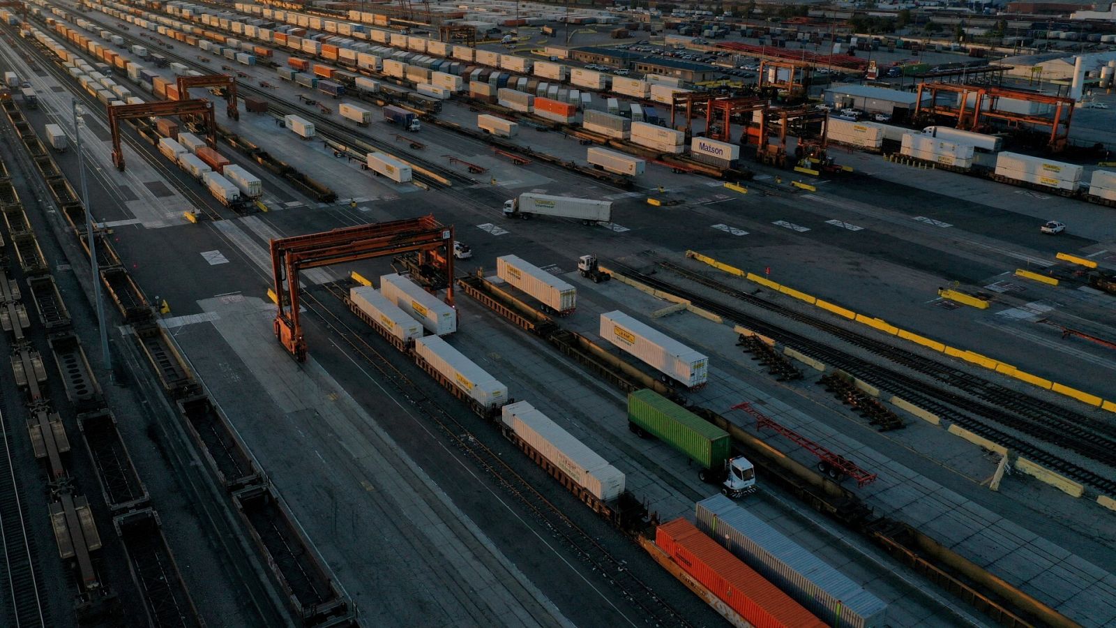 Vista aérea en Los Ángeles de grúas de pórtico, contenedores de transporte y trenes de mercancías ante una posible huelga ferroviaria en Estados Unidos.
