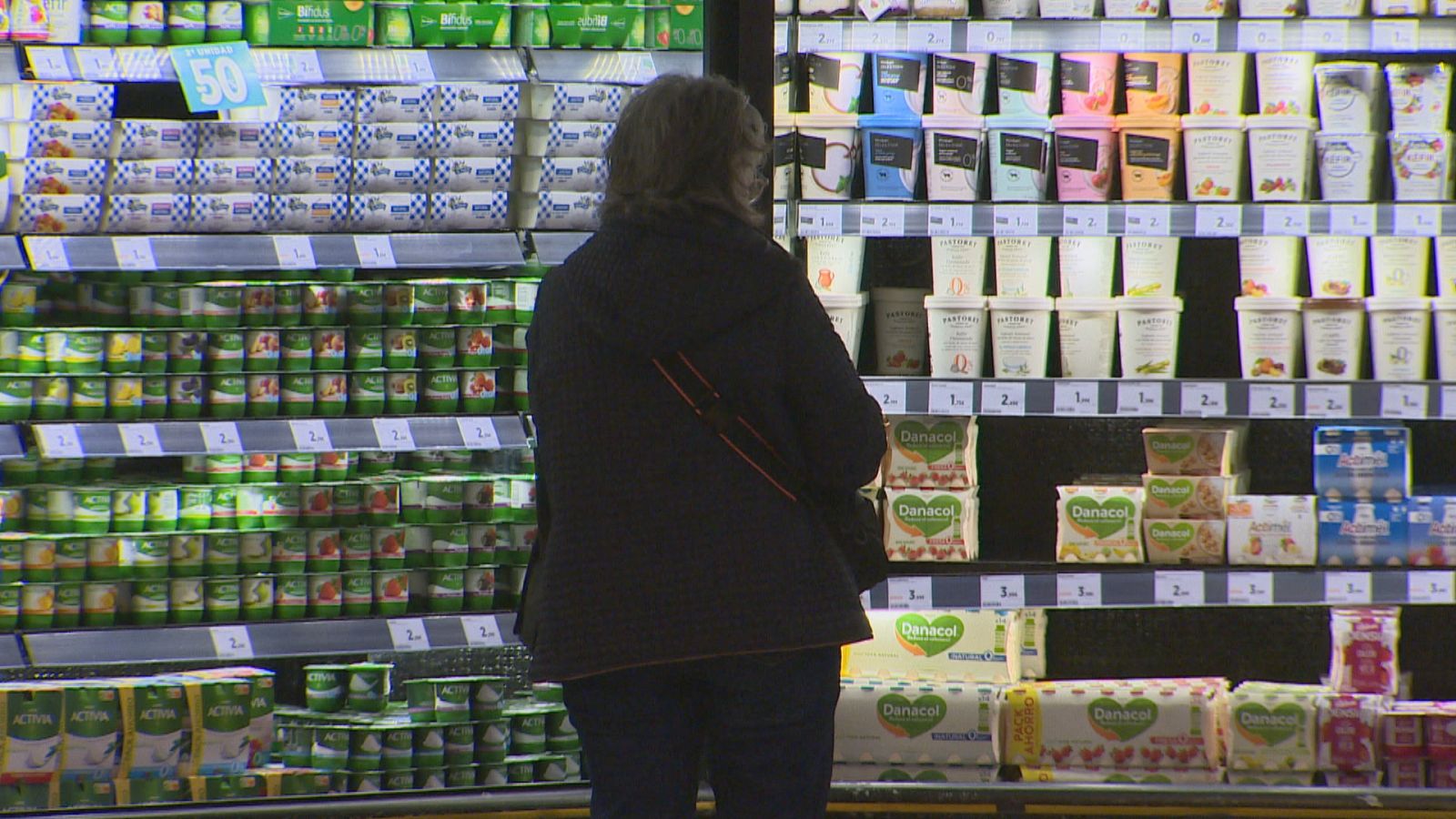 Una dona fa la compra de productes d'alimentació a un supermercat