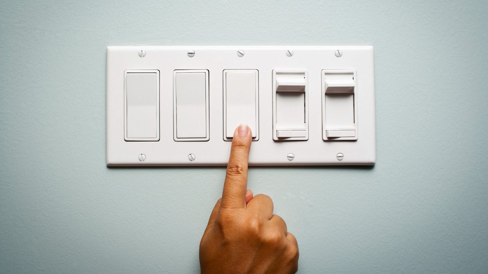 Una persona enciende un interruptor de la luz