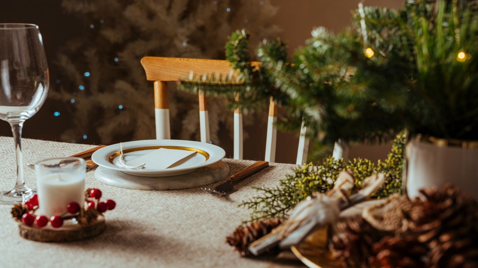 Una silla vacía junto a una mesa decorada por Navidad