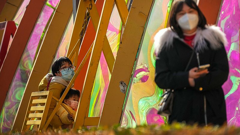 Una mujer columpia a un niño en un centro comercial