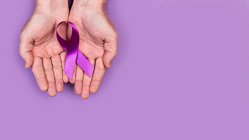 Una mujer sostiene un lazo rosa, símbolo contra la violencia machista