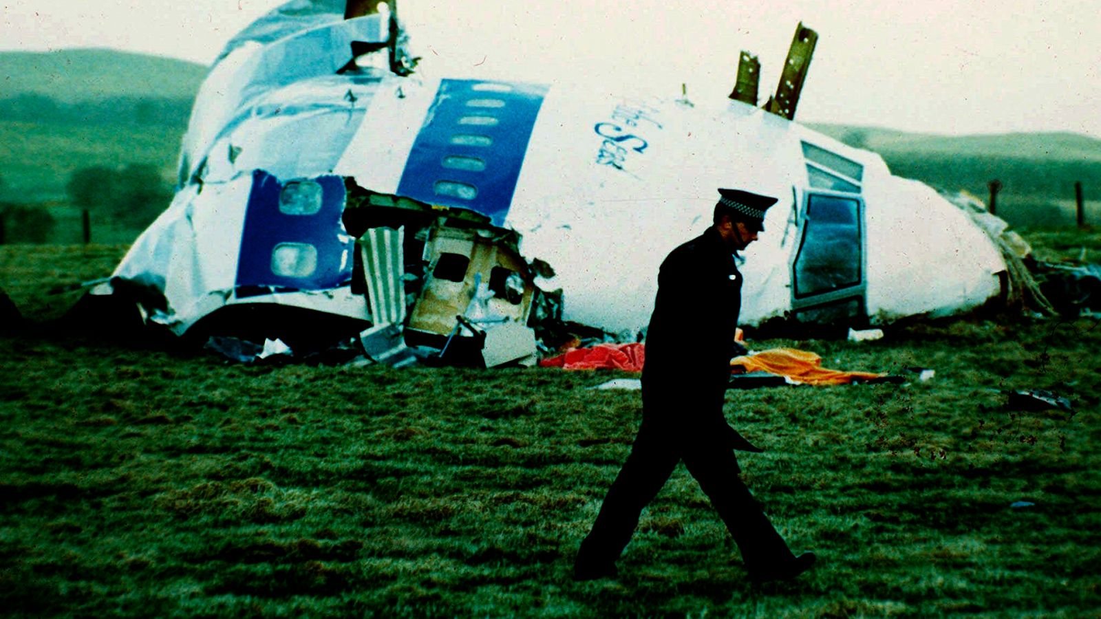 Un oficial de policía camino en los alrededores del avión atacado en Lockerbie