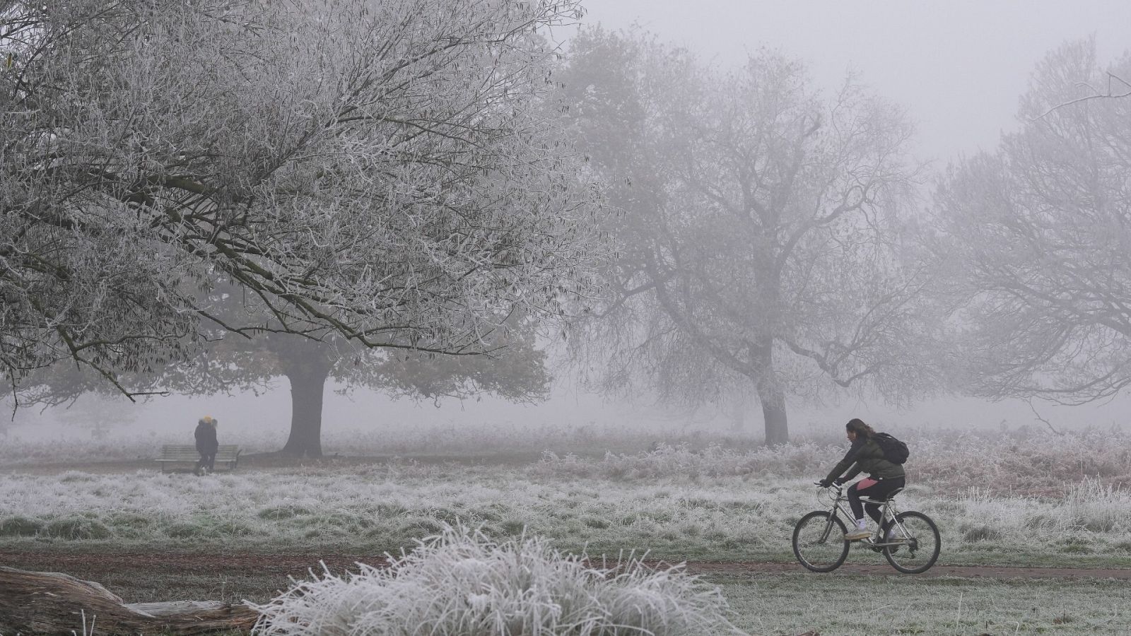 Una ciclista cruza un parque nevado en Londres